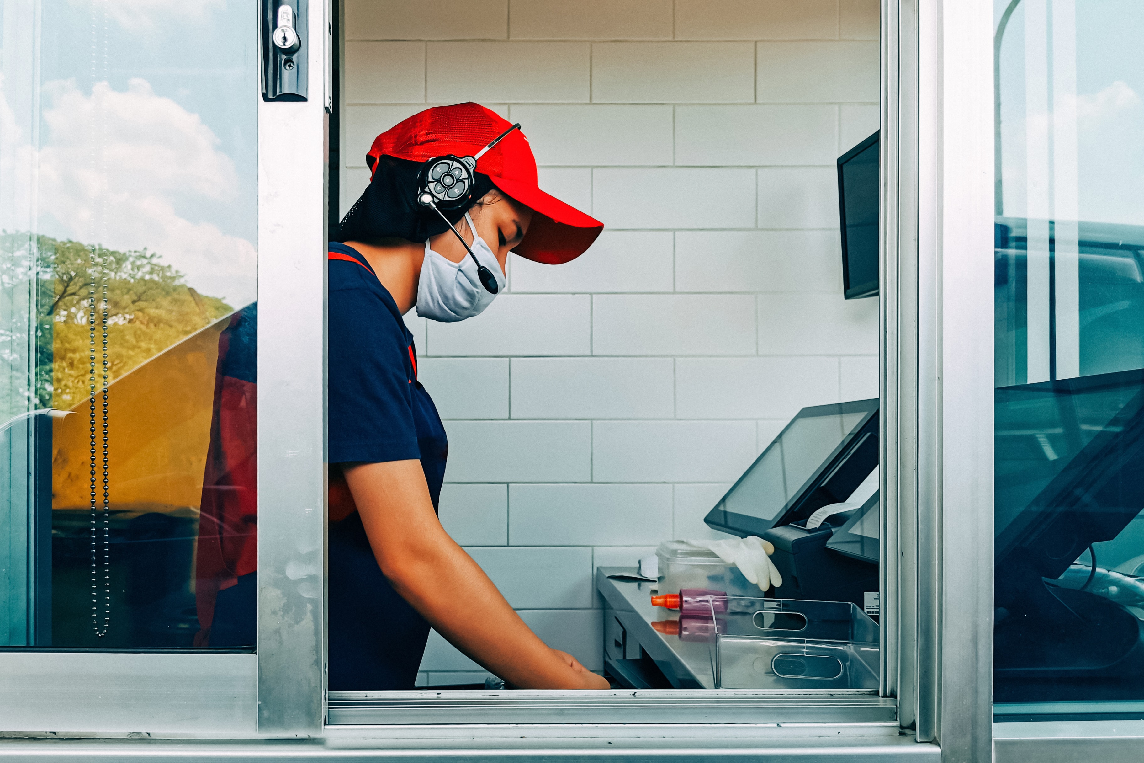 restaurant worker during COVID-19 pandemic working the drive-thru