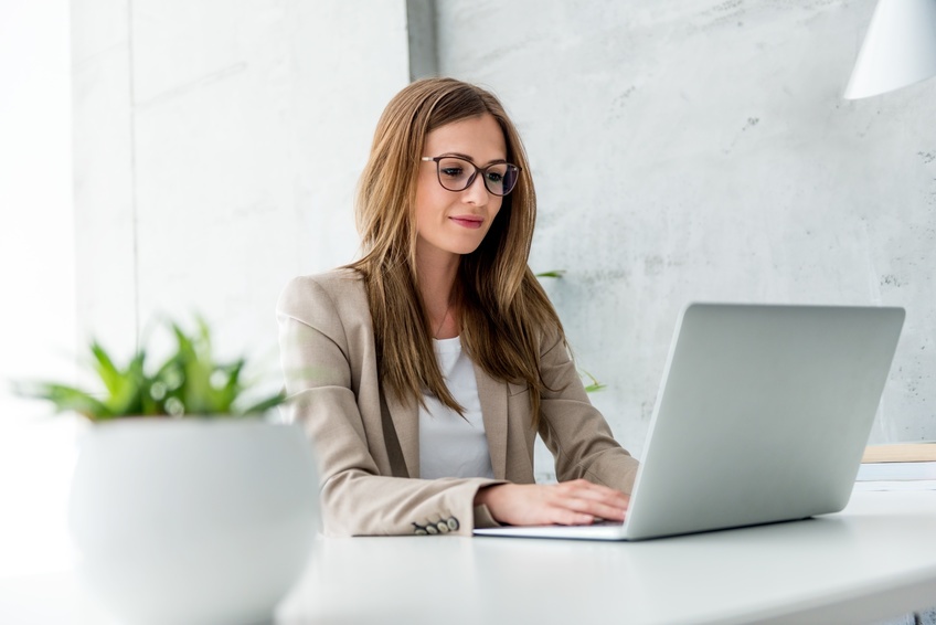 woman researching field management systems on a laptop