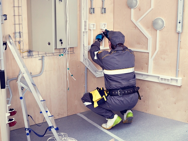 field service technician installing cables and wires in a wall